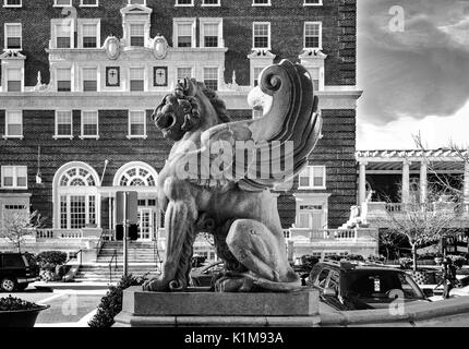 Ein geflügelter Löwe Statue aus dem Grove Arcade im Profil, mit dem Battery Park Hotel im Hintergrund, in Asheville, North Carolina Stockfoto