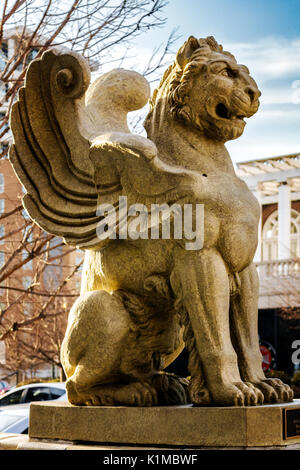 Eine Statue von einem geflügelten Löwen mit Ästen und den Teig Park Hotel im Hintergrund in Asheville, North Carolina, USA Stockfoto