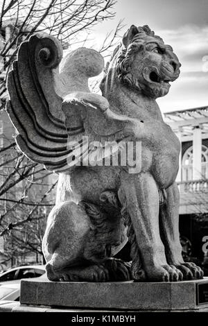 Eine Statue von einem geflügelten Löwen mit Ästen und den Teig Park Hotel im Hintergrund in Asheville, North Carolina, USA Stockfoto