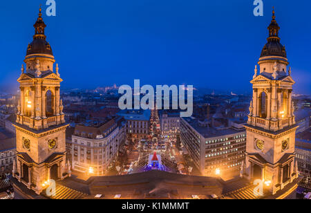 Budapest, Ungarn - Panoramablick auf die Skyline von Budapest von der St.-Stephans-Basilika im Blue Hour im Winter mit Weihnachtsmarkt Stockfoto