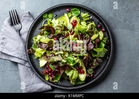 Blattsalat mit Granatapfel auf schwarze Platte, Schiefer-Hintergrund Stockfoto