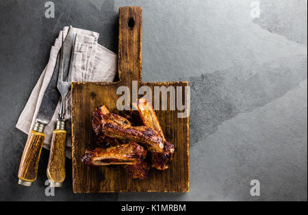 Schweinerippchen auf Cutting Board, Schiefer Hintergrund. Ansicht von oben Stockfoto