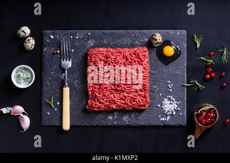 Frische Metzger schneiden Fleisch Hackfleisch, garniert, mit Kochen Zutaten serviert. Oben betrachten. Stockfoto