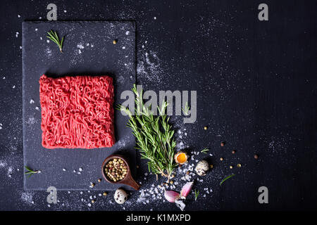Rohes Fleisch, Rindfleisch Steak auf schwarzem Hintergrund, Ansicht von oben, kopieren. Stockfoto