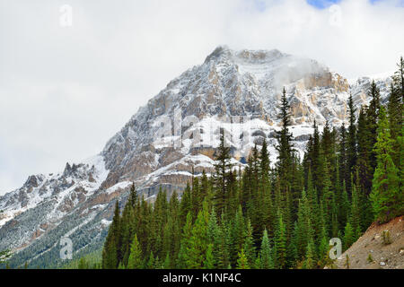 Hohe Berge der Kanadischen Rockies durch Wolken entlang des Icefields Parkway zwischen Banff und Jasper umgeben Stockfoto