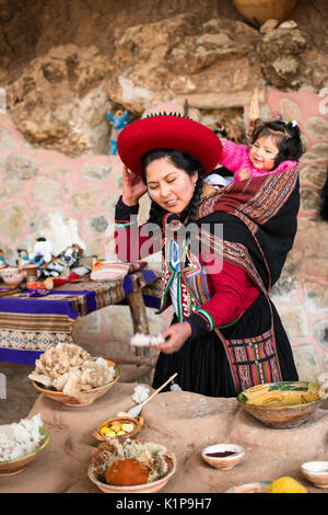 Mutter und Kind in Papoose, Chinchero, Peru, Weber, Farbstoff Demonstration der Gemeinschaft Stockfoto