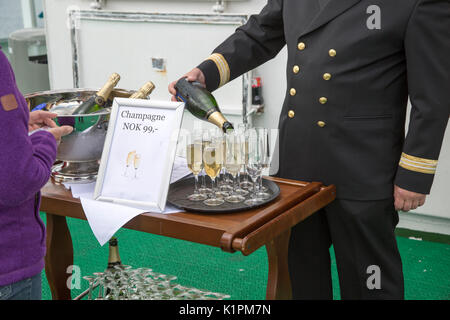 Champagner feier Überquerung des Polarkreises in Richtung Süden, Norwegen Hurtigruten Fähre Schiff, Offizier in Gläser gießen von der Flasche Stockfoto