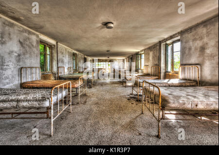 Verfallene Schlafsaal in einem verlassenen Kinder Krankenhaus Stockfoto