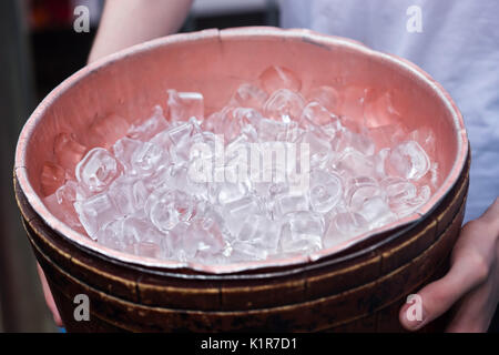 Männliche halten Behälter mit Eiswürfel Stockfoto