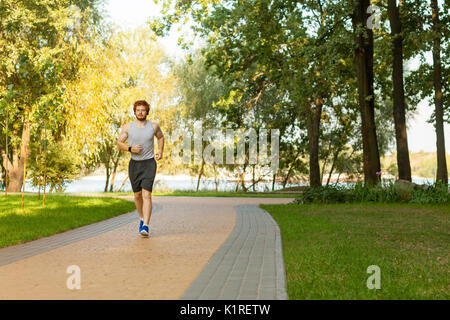 Redhead und sommersprossige Mann laufen im Park im Sommer morgen. Gesunder Lebensstil Konzept Stockfoto