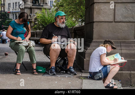 Barcelona, Spanien. 27 Aug, 2017. Drei Teilnehmer am Plaza Catalunya sitzt konzentriert, während Sie zeichnen. Barcelona Urban Sketchers Hommage an die Opfer des Terroranschlags von Barcelona und Cambrils unter dem Slogan "Ich fürchte mich nicht. Zeichnung auf der Straße 'Credit: SOPA Images Limited/Alamy leben Nachrichten Stockfoto