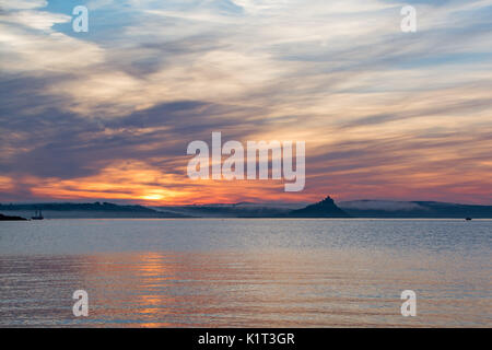 Penzance und Marazion, Cornwall, UK. 28. August 2017. UK Wetter. Am frühen Morgen Nebel begann bei Sonnenaufgang über St. Michaels Mount, wo der rote Fluss, der ins Meer läuft mit Marazion zu heben. Wie von Penzance gesehen, dann der Strand von Marazion kurz nach Sonnenaufgang. Foto: Simon Maycock/Alamy leben Nachrichten Stockfoto