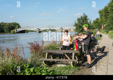 Die Menschen genießen einen Drink, in der Nähe der Themse, außerhalb der White Hart Pub in Barnes, London, SW13, UK. Stockfoto