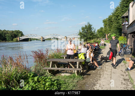 Die Menschen genießen einen Drink, in der Nähe der Themse, außerhalb der White Hart Pub in Barnes, London, SW13, UK. Stockfoto