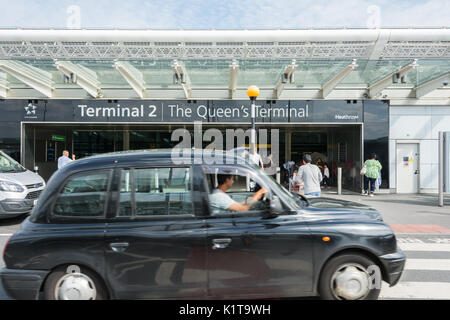 Ein schwarzes Taxi vor dem Heathrow Airport Terminal 2 Gebäude, dem Queens Terminal, London, England, Großbritannien Stockfoto