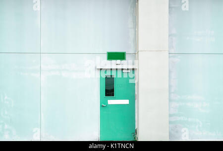Geschlossene grüne Tür mit grünen Textfeld auf grün Betonwand mit Kopie Raum Stockfoto