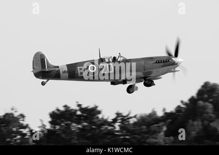 Supermarine Spitfire Mk IX klassische britische Weltkrieg 2 Kampfflugzeug fliegen am Start für eine Anzeige. Seitenansicht Foto umgewandelt in den Schwarzweiß-Modus. Stockfoto