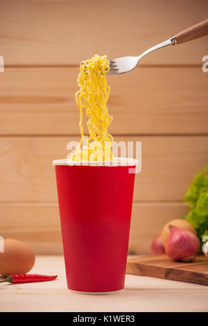 Essen Instant Nudeln in Tasse mit einer Gabel Stockfoto