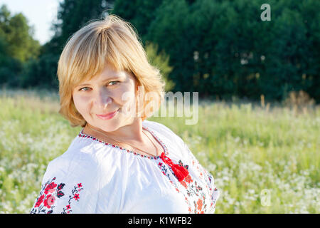 Glückliche Frau in der Natur Hintergrund lächelnd. Stockfoto