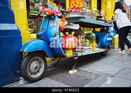 Blau Motorrad Anzeige mit Obst, Gemüse, verspottet, Buddha Kopf vor der chinesischen Shop, Chinesisch Full Moon Festival, Dublin, Irland, 26. August Stockfoto