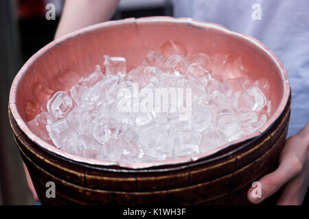 Männliche halten Behälter mit Eiswürfel Stockfoto