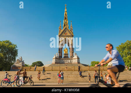 London Sommer radfahren, an einem Sommernachmittag Touristen auf dem Fahrrad besuchen Sie das Albert Memorial am Eingang zu den Kensington Gardens, London, UK Stockfoto