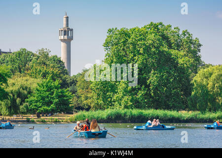 Regent's Park, London, Blick auf den See zum Bootfahren und Touristen genießen Sie einen Nachmittag mit dem Minarett der Moschee an der Rückseite, UK. Stockfoto