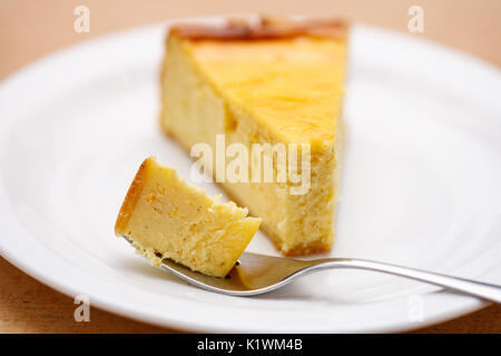 Scheibe der Plain New York Cheesecake auf weiße Platte Stockfoto