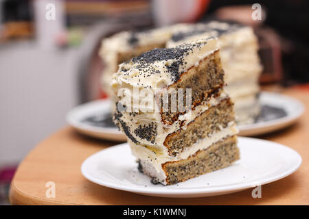 Biskuitteig mit Mohn mit Creme mit ein ausgeschnittenes Stück Kuchen 2-in-1 Stockfoto