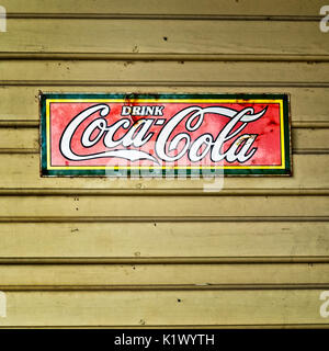 Feder TX USA - Juli 12, 2017 - Alte trinken Coca-Cola Stahl Zeichen auf gelbes Gebäude in der Altstadt Frühling TX Stockfoto