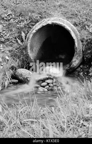 Kleiner Wasserfall von Abflussrohr bei Kiwanis Park in Schwarz und Weiß Stockfoto