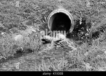 Kleiner Wasserfall von Abflussrohr bei Kiwanis Park in Schwarz und Weiß Stockfoto