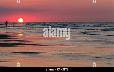 Angeln im Meer bei Sonnenuntergang Stockfoto