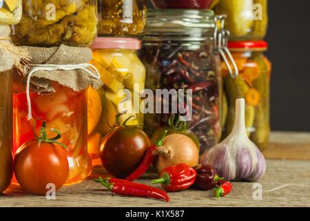 Gläser mit verschiedenen eingelegtes Gemüse. Karotten, Knoblauch, Petersilie in Glas. Konserven. Fermentierte erhalten vegetarisches Essen Konzept Stockfoto