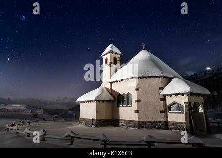 Die kleine Kirche von San Pellegrino Pass, zwischen Agordino und Fassa Tal in den Dolomiten, Trentino. Ein Winter kalten Abend bei klarem Himmel ein Stockfoto