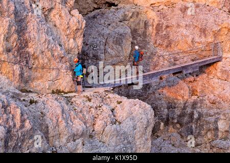 Europa, Italien, Venetien, Belluno. Zwei Wanderer auf der Hängebrücke mit Stahlseilen entlang der Kaiserjaeger Trail, Lagazuoi, Dolomiten Stockfoto