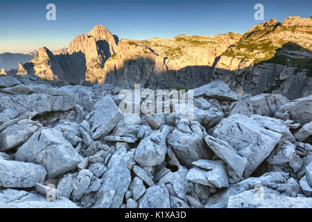 Steinigen Boden auf den ersten Pala di San Lucano, im Hintergrund mount Agner und Seconda Pala bei Sonnenaufgang. Dolomiten, Agordino, Belluno, Venetien, Italien, Euro Stockfoto