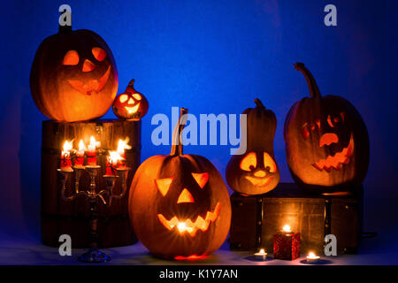 Fünf Halloween Kürbisse, frohe Gesichter auf einem blauen Hintergrund. Stockfoto