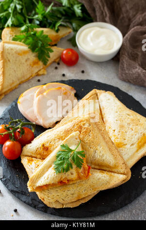 Gedrückt und gerösteten double Sandwich mit Huhn, Koreanisch Karotten, Käse und Tomaten auf grauem Stein oder Schiefer. Stockfoto