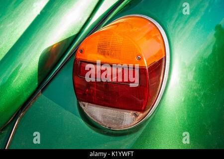 Detailansicht der hinteren Licht einer alten Vintage oder retro Auto. Kontrast von Orange, Rot, Weiß und Grün. Sonnendurchflutete helle und lebendige Szene. Stockfoto