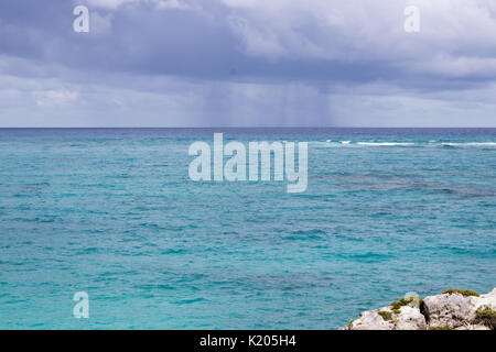 Sturm squall über die Karibik als tropischer Sturm Harvey geht. strahlend blauen Meer, Regen sichtbar unter entfernten Wolke. Stockfoto