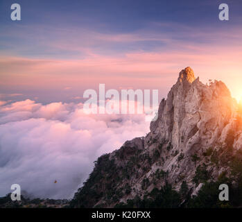 Berge bei Sonnenuntergang. Unglaubliche Aussicht vom Berg auf den hohen Felsen, blauer Himmel, rosa Wolken und am Abend. Niedrige Wolken. Farbenfrohe Natur Stockfoto