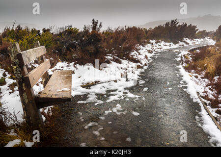 Alte Holz- Sitz auf der Nordschleife bei tonagriro Nationalpark Track nach einem Schnee dump im Winter Stockfoto