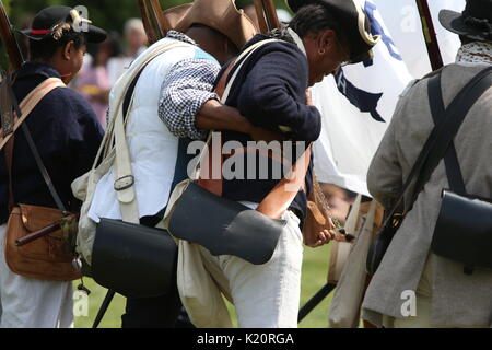 Brooklyn, Vereinigte Staaten. 27 Aug, 2017. Green-Wood Cemetery in Brooklyn inszeniert seine jährliche Schlacht von Brooklyn, Freizeit, mit Kanonen und Musketen Feuer komplett, mit Re-enactors tragen Britische & Kolonialzeit Uniformen auf dem Friedhof rasen. Nach der Schlacht, Truppen den Weg zu Battle Hill, wo eine kurze Zeremonie stattfand, mit Kränzen in Platz zu Ehren des 400 Maryland Infanterie, die rund 70% Verluste angreifenden britischen Positionen auf dem Hügel ausgehalten. Credit: Andy Katz/Pacific Press/Alamy leben Nachrichten Stockfoto