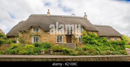 Panoramablick auf das malerische Reetdachhäuser mit bunten Garten in der Nähe von Dorf Hilcote, England Stockfoto