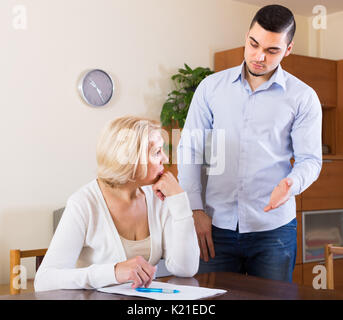Finanzkrise in Familie depressiver erwachsener Sohn und seine traurige ältere Mutter Stockfoto