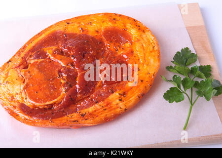 Rohes Schweinefleisch Schinken mit Gewürzen und Petersilie bereit für BBQ grillen auf weißem Hintergrund. Stockfoto