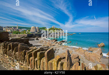 Weitläufige Stadt durch geschützten Strand gesäumt, und blauen Wasser des Ozeans an der felsigen Küste Läppen unter blauem Himmel in Ilfracombe, Devon, England Stockfoto