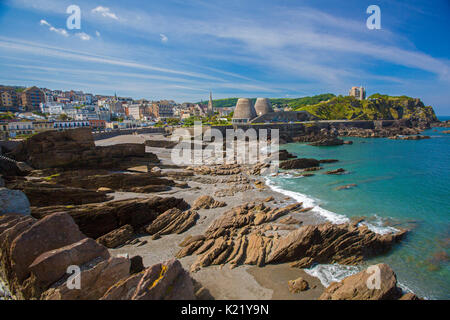 Weitläufige Stadt durch geschützten Strand gesäumt, und blauen Wasser des Ozeans an der felsigen Küste Läppen unter blauem Himmel in Ilfracombe, Devon, England Stockfoto