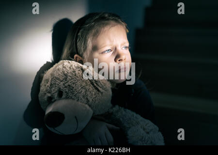 Trauriges kleines Mädchen umarmt ihren Teddy Bär - fühlt sich einsam - wenn Sie sind kleine Mädchen Teddybär bereit ist, Ihr bester Freund zu sein - vintage Filter angewendet Stockfoto